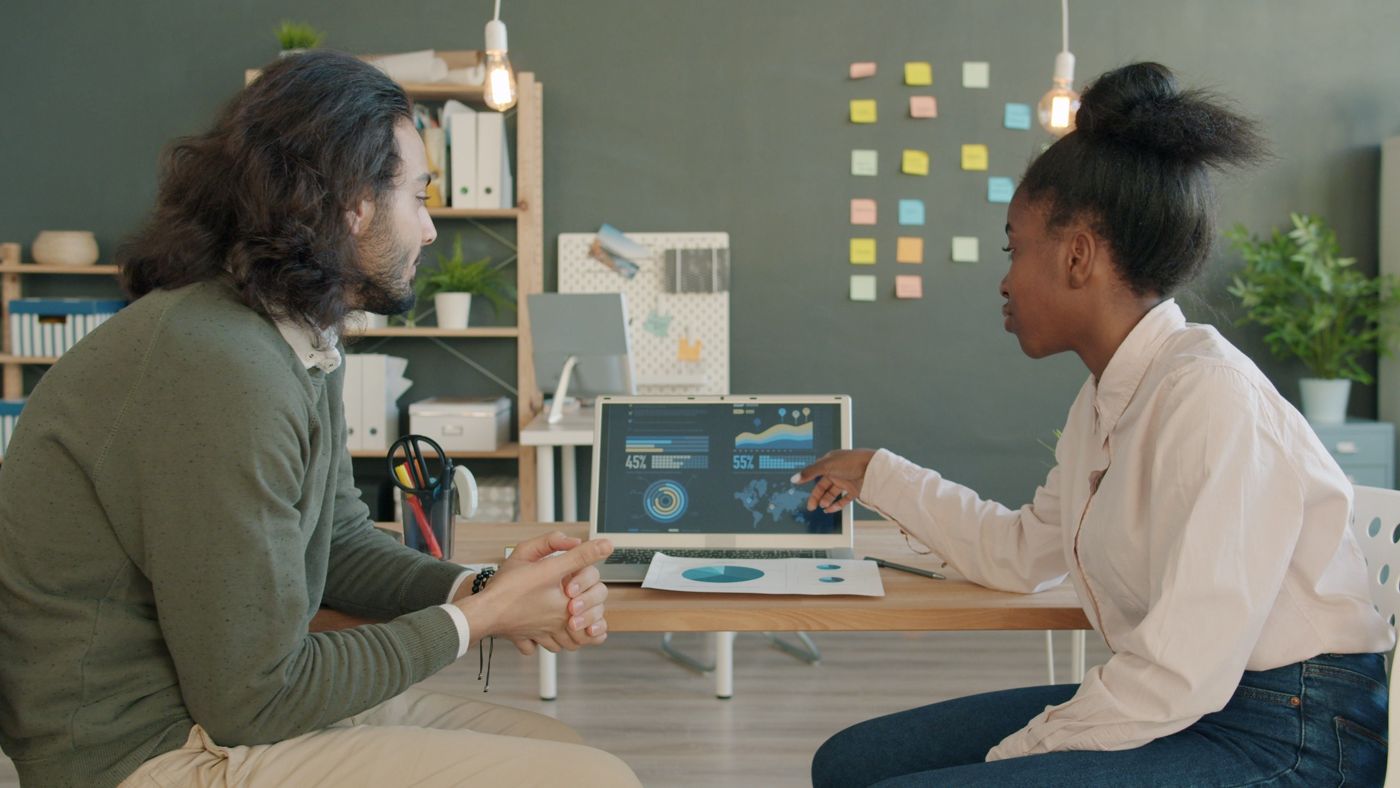 Séance de coaching : deux personnes analysent un tableau de bord sur un ordinateur portable